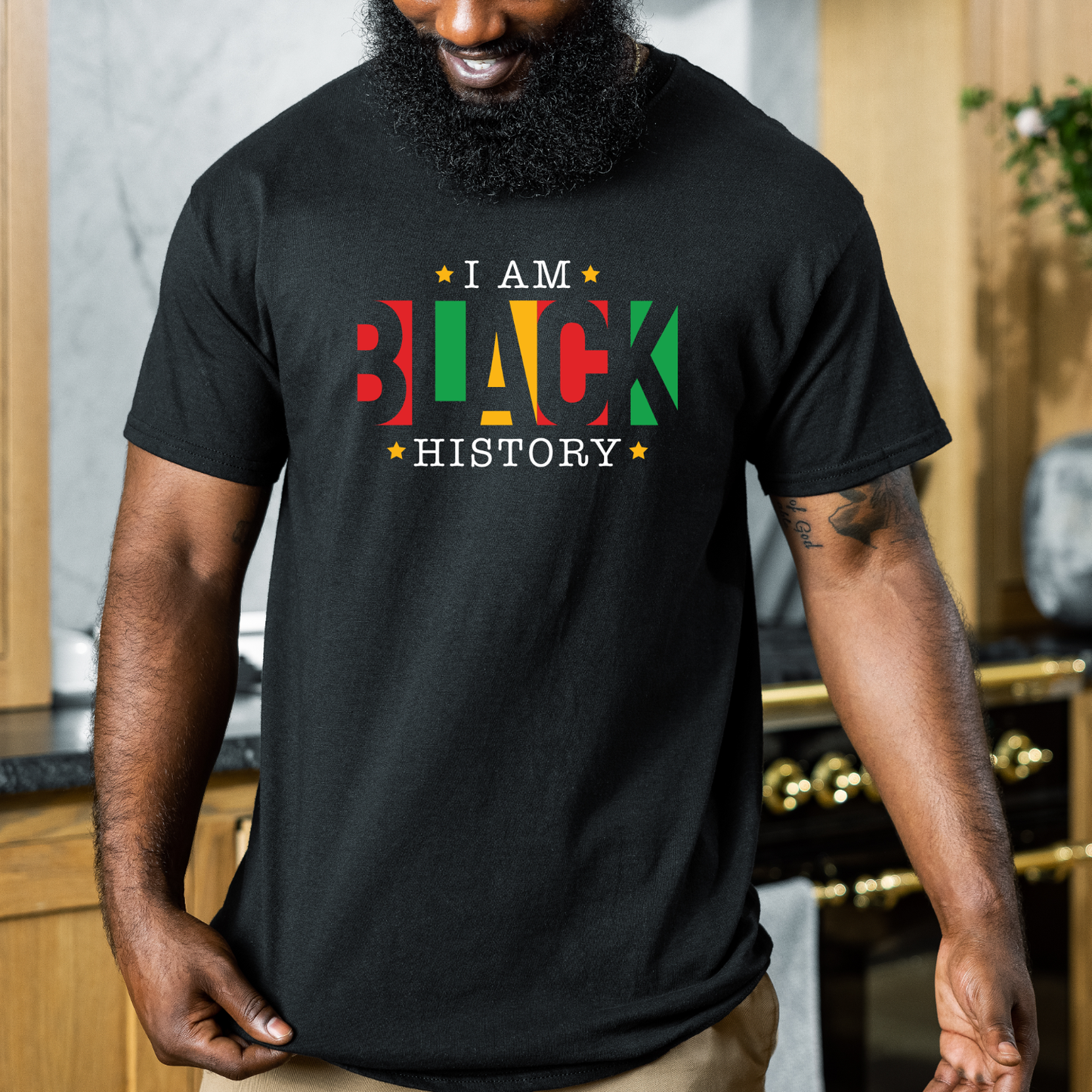 Person wearing a black t-shirt with 'I AM BLACK HISTORY' text in multicolors.